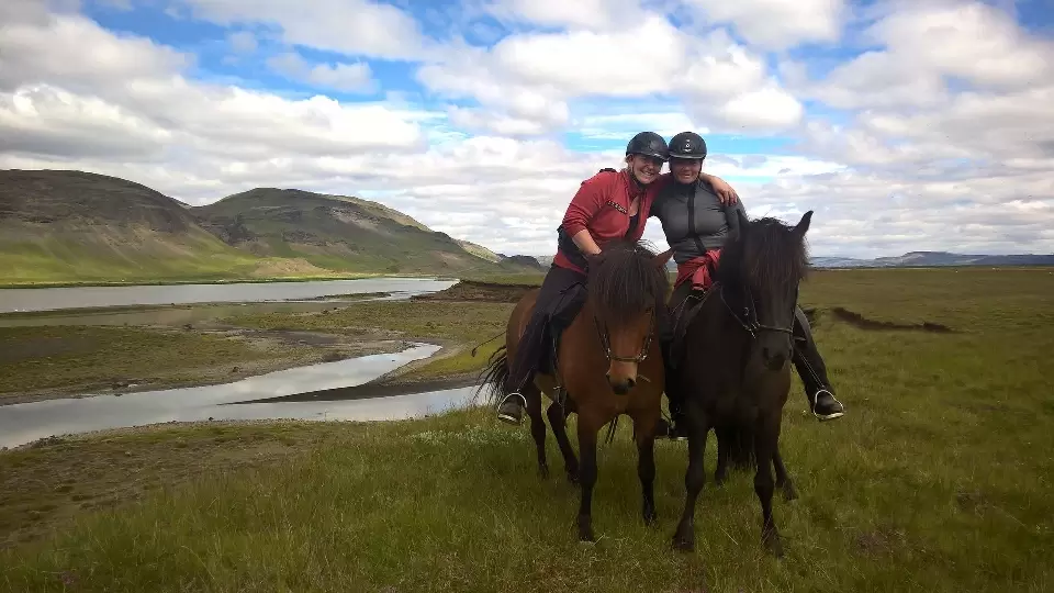 A horse and rider tölting in front of Búrfell mountain.