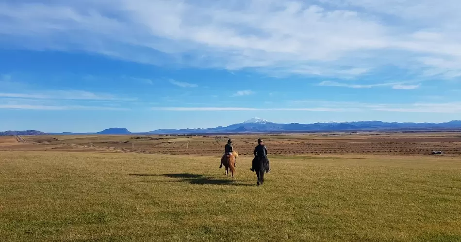 Two riders on Icelandic horses in front of volcano Hekla 