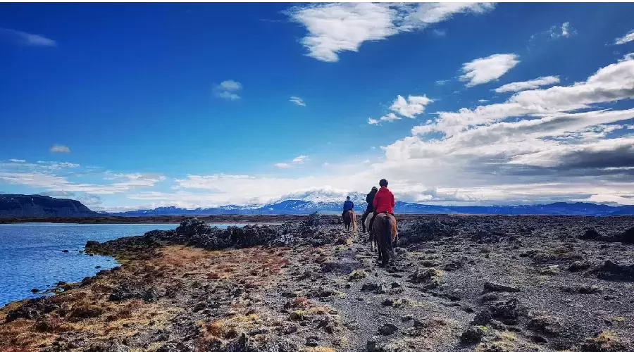A group of riders riding through a lava field.