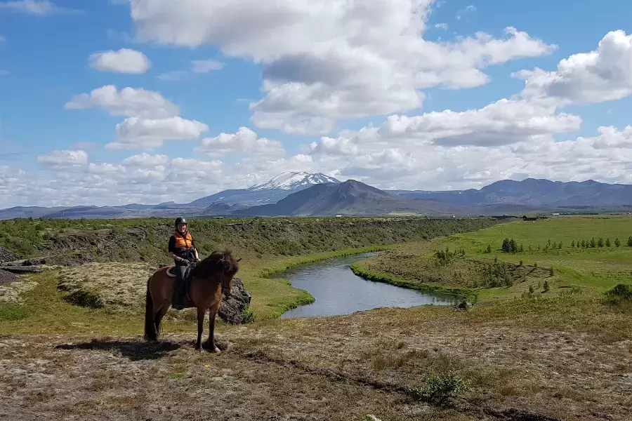 A rider and her Icelandic horse in front of volcano Hekla 